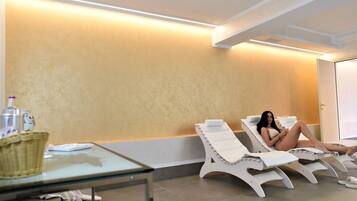 Relax in a serene space with two reclining chairs and a glass table.