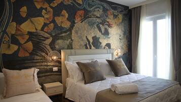A hotel room with two beds, a mural on the wall, and a window with curtains.
