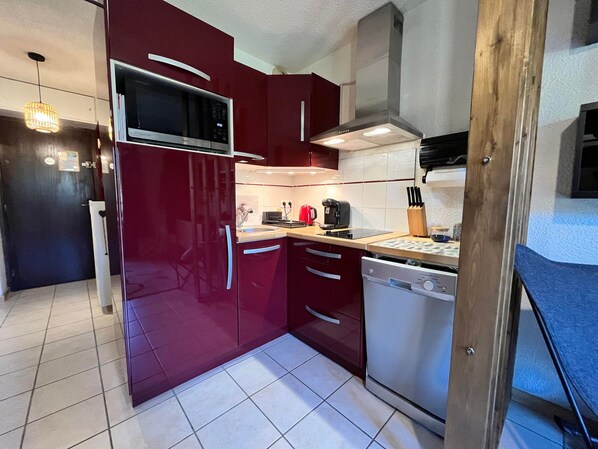 A compact kitchen with a microwave, stove, and dishwasher.