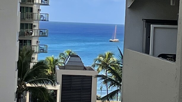 A view of a high-rise building with balconies overlooking a beach and ocean. - Modern Ocean View Studio - Waikiki Paradise! (Honolulu)