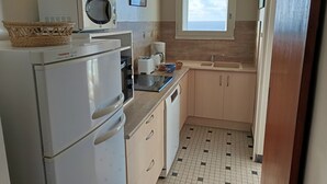 A compact kitchen with a refrigerator, microwave, toaster, and sink. - Sea view apartment in Notre-Dame-de-Monts - 5 people, pets (Notre-Dame-de-Monts)