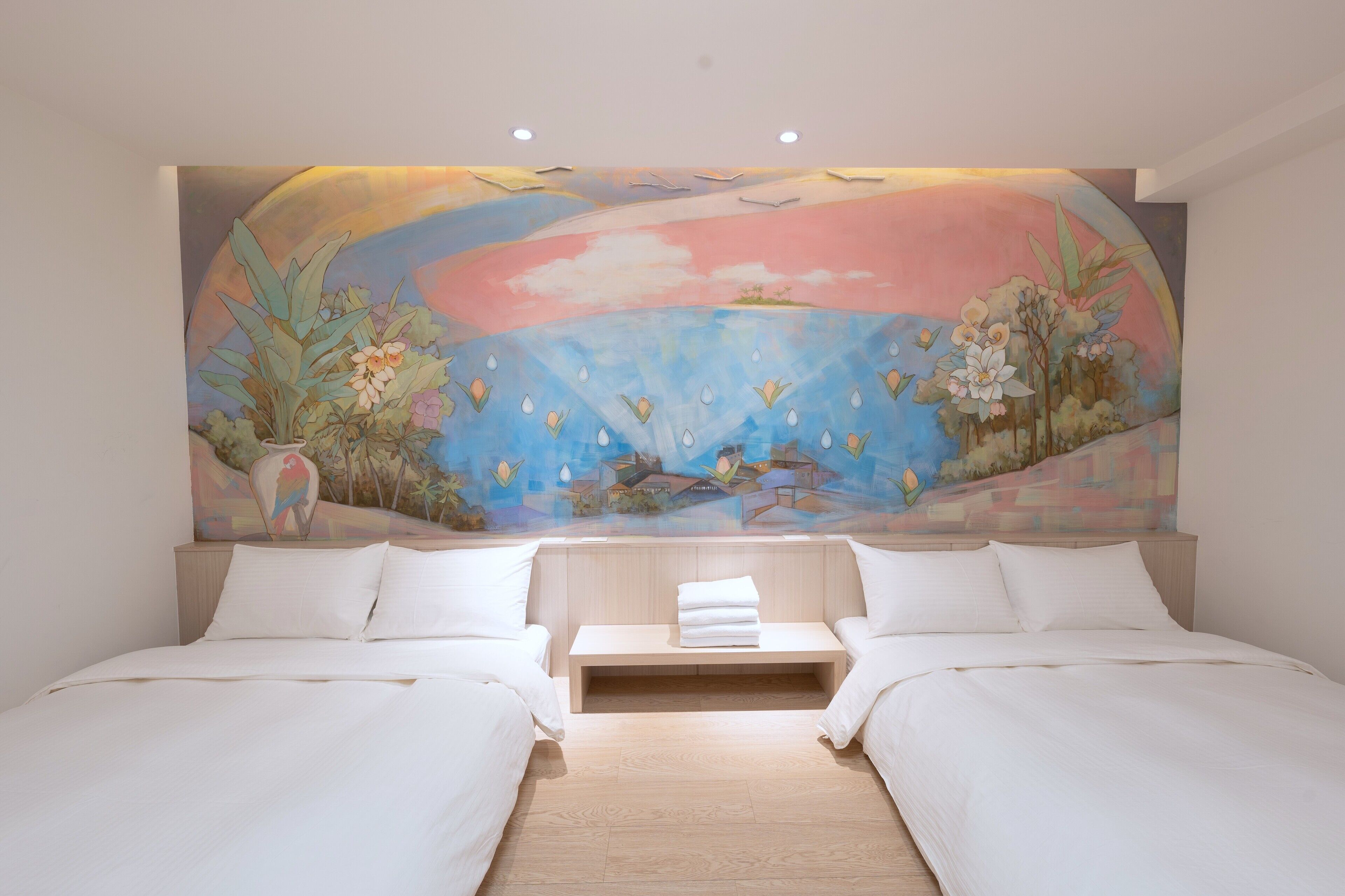 A bedroom with two beds, a wooden headboard, and a mural of a landscape with flowers and birds.