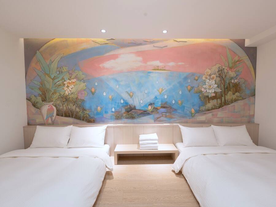 Une chambre avec deux lits, une tête de lit en bois et une fresque murale représentant un paysage avec des fleurs et des oiseaux.