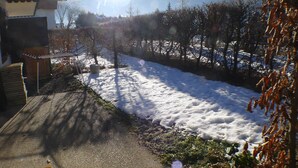 A snowy landscape with a clear sky, a wooden deck, and a mountain in the background. - Cozy apartment, 3 rooms, garden, quiet, near Samoëns center (Samoëns)