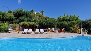 A swimming pool with lounge chairs and a stone pathway. - Villa Emiliata (Spartia)
