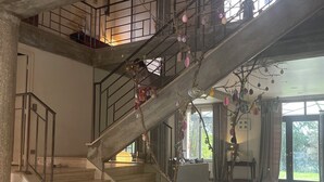 Una escalera de varios niveles con una rama de árbol adornada con adornos.