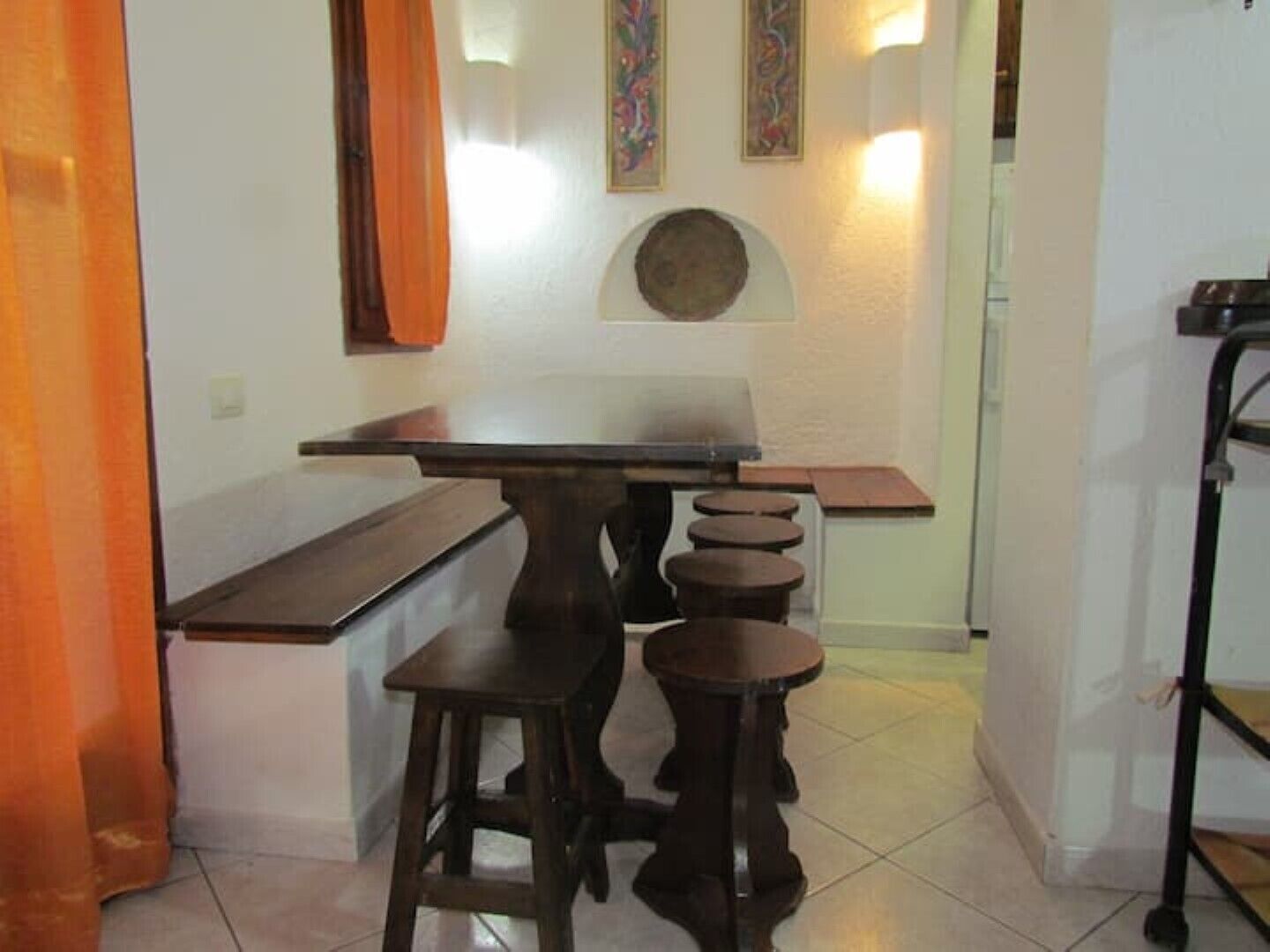 Un petit coin bar avec une table en bois foncé et des tabourets.