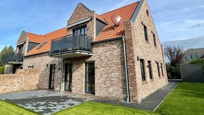 A two-story brick house with a red-tiled roof, a balcony with metal railings, and a satellite dish. - Vacation apartment Starboard Greetsiel (Greetsiel)