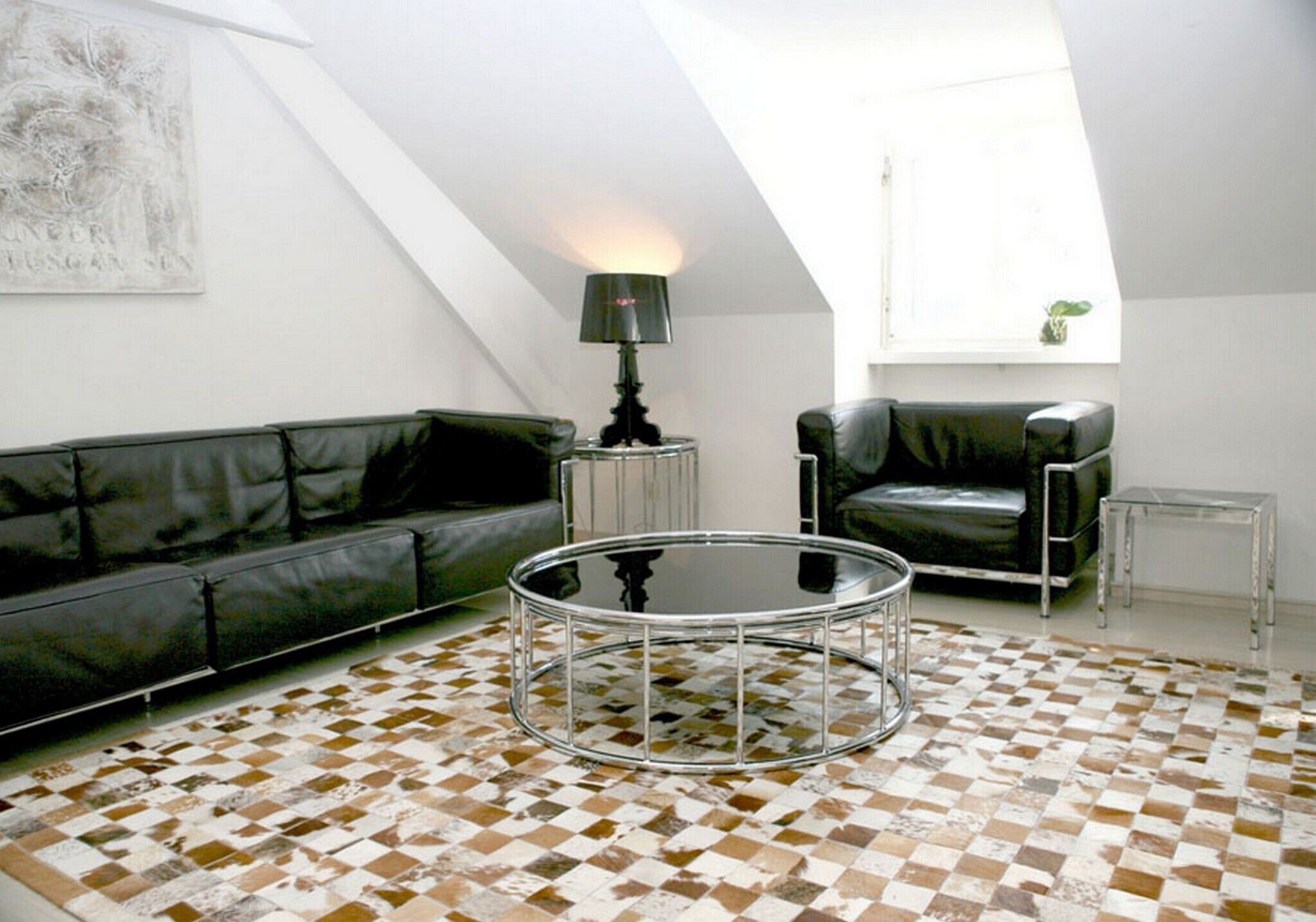 Uma sala de estar moderna com piso xadrez, um sofá de couro preto, uma poltrona de couro preto, uma mesa de centro de vidro e uma luminária.