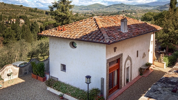 A small, single-story building with a tiled roof, a stone chimney, and a small circular window. - The Chapel - ancient little country church (GRASSINA)