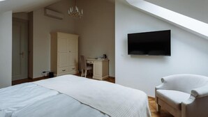 A bedroom with a bed, a desk, a chair, a television, and a wardrobe. - Elegant Suite 4 (Hlavní město Praha)