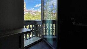 A balcony with a view of a building and trees. - Blloku Unique Apartments (Tirana)