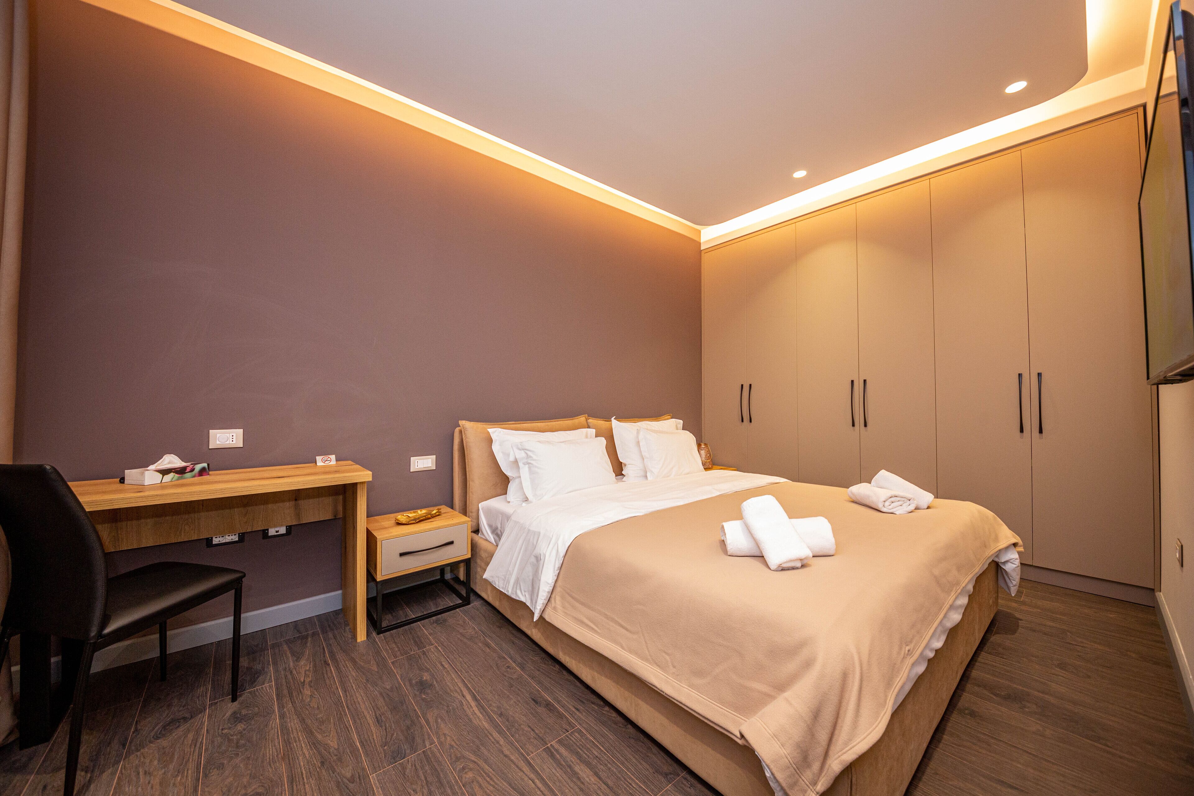 Una habitación de hotel con cama, escritorio, silla y armario.