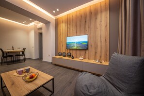 Apartment, 1 Bedroom, Balcony | Living area | 50-inch Smart TV with cable channels, TV