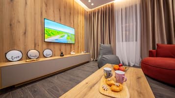 Apartment, 1 Bedroom, Balcony | Living area | 50-inch Smart TV with cable channels, TV