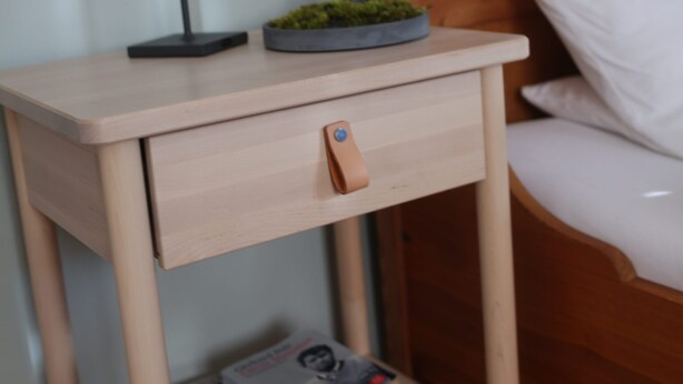 A wooden bedside table with a lamp, a small plant, and a book. - PrienZeit vacation apartment with fantastic panoramic views (Aschau)