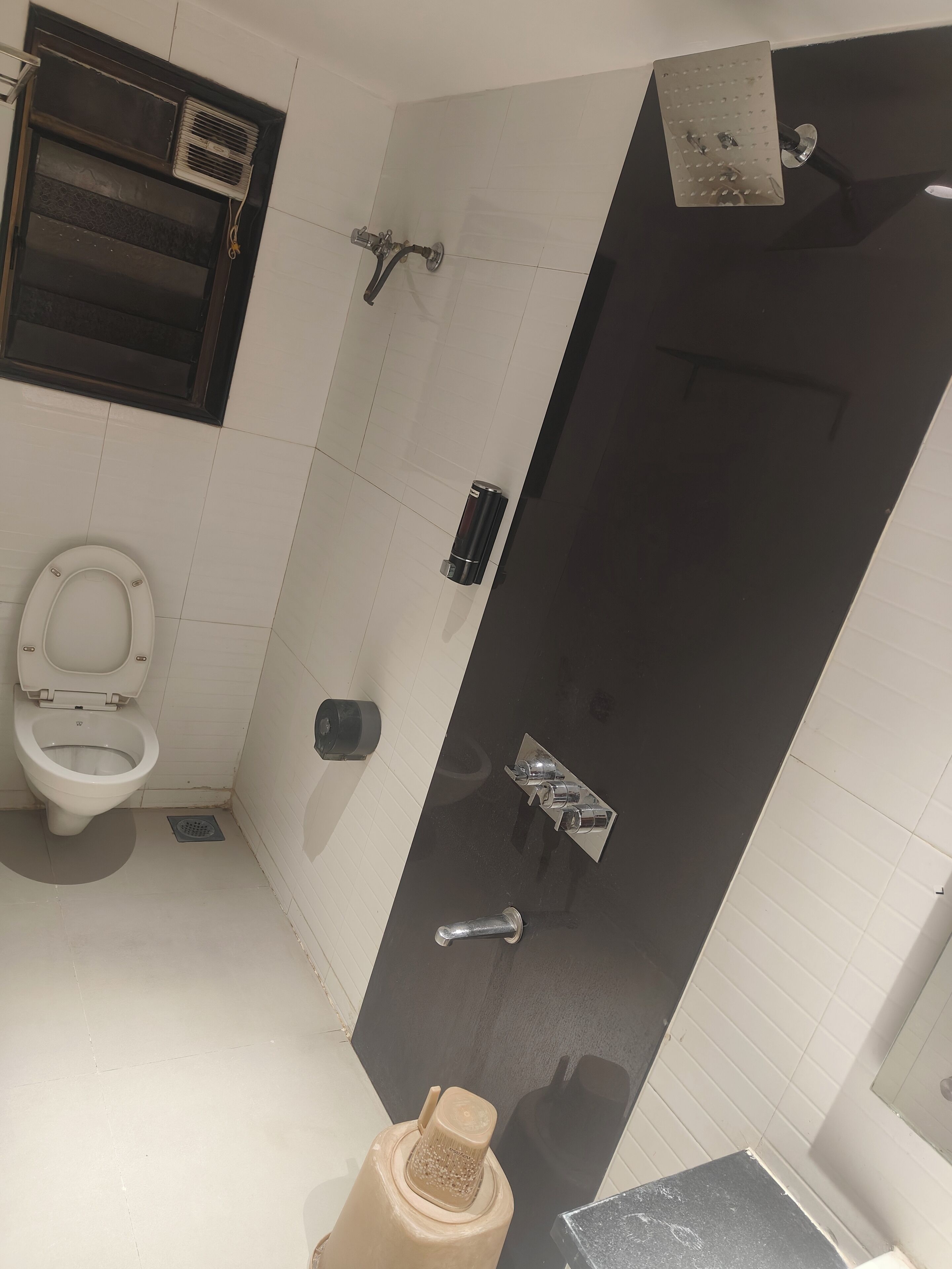 A bathroom with a toilet, a shower, and a sink.