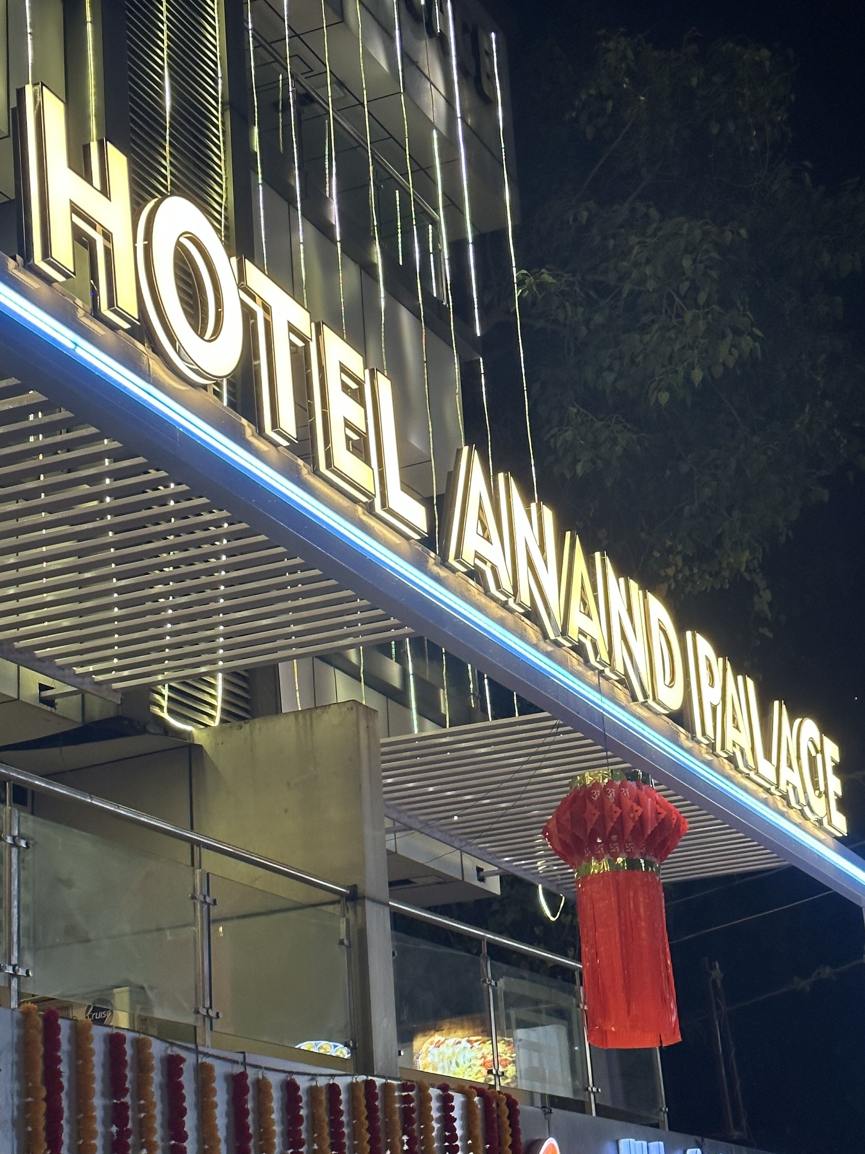 Un letrero de hotel con el nombre "HOTEL ANAND PALACE".