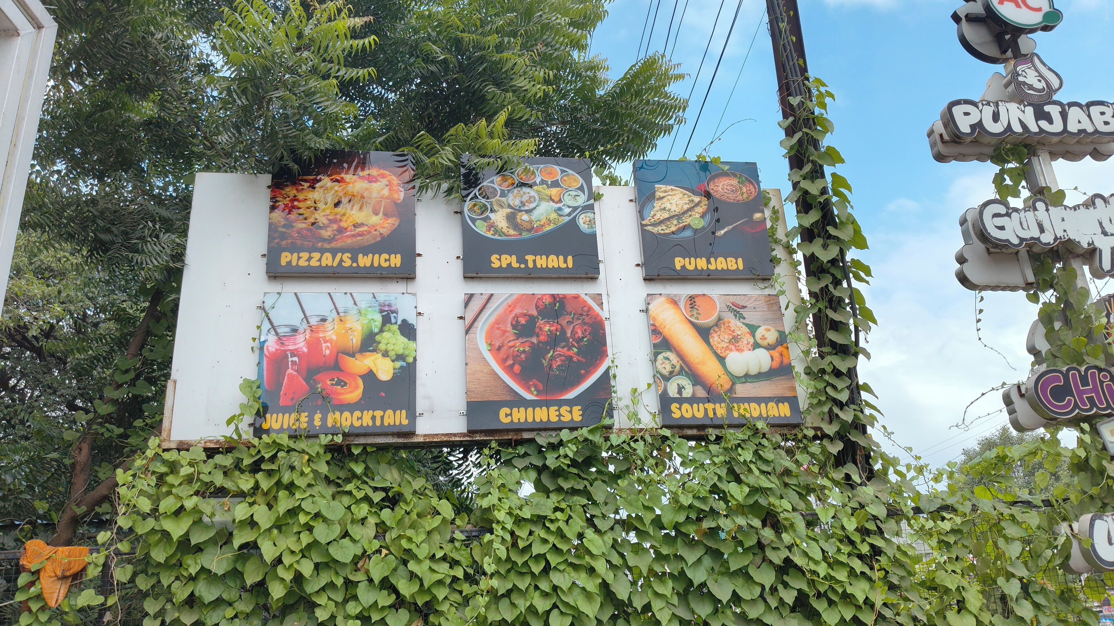 Eine Speisekarte mit verschiedenen Gerichten, darunter Pizza, Thali, Punjabi, Chinesisch und südindische Küche.