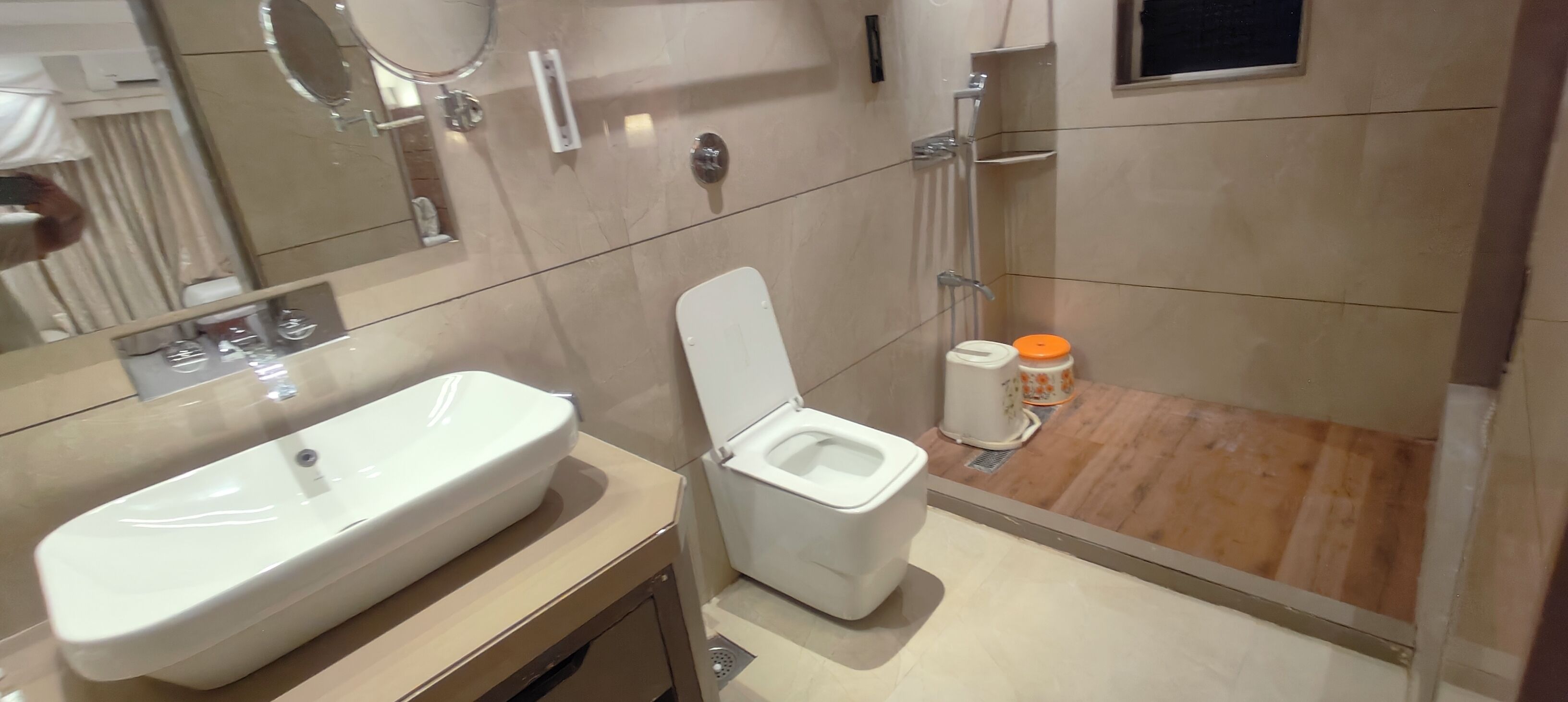Ein modernes Badezimmer mit Waschbecken, Toilette und Dusche in Weiß.