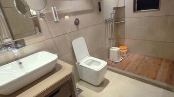 Ein modernes Badezimmer mit Waschbecken, Toilette und Dusche in Weiß.