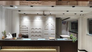 Un comptoir d’accueil agrémenté de motifs complexes sur les murs, une horloge et une plante.