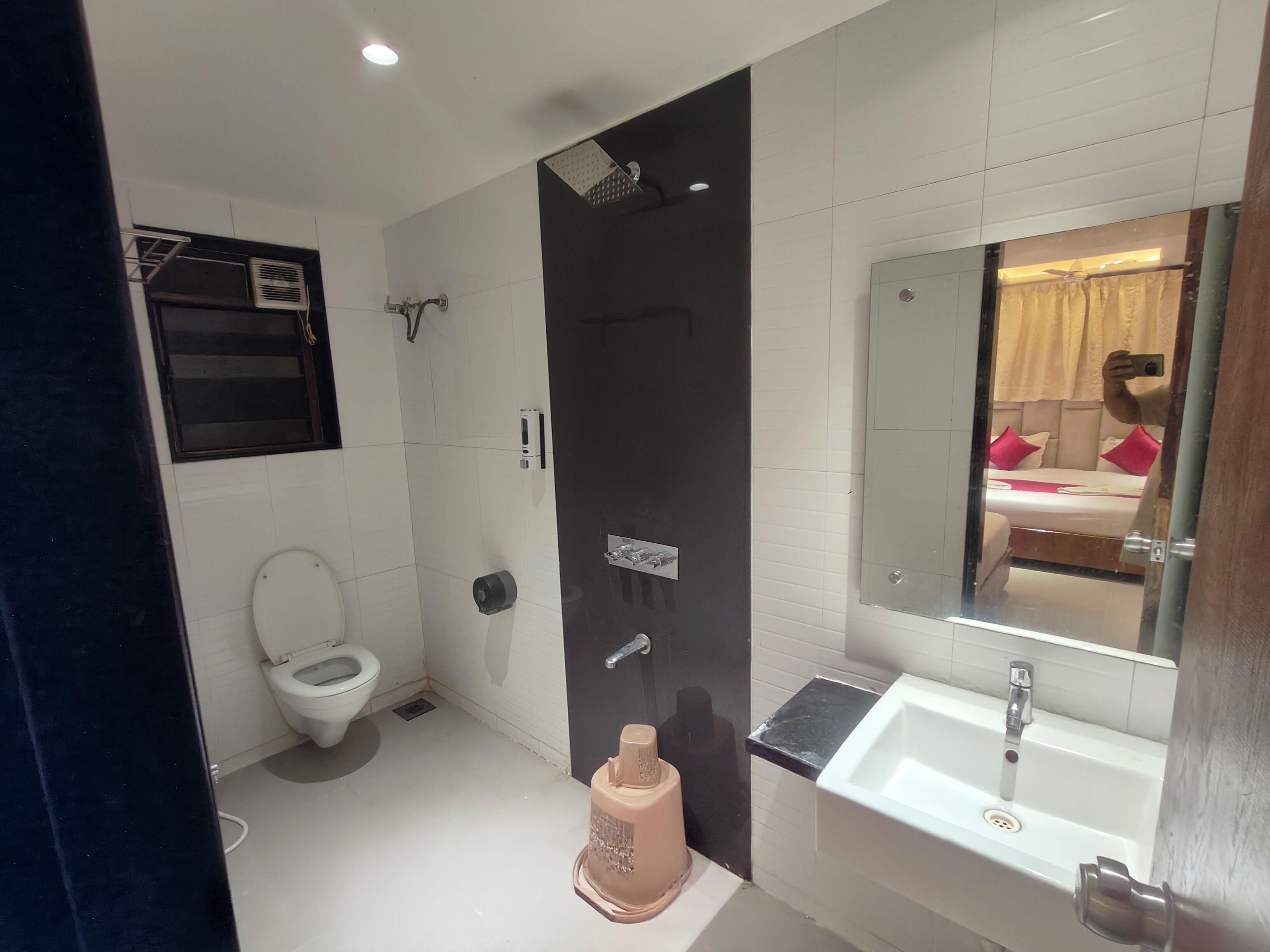 A modern bathroom with a toilet, shower, and sink.