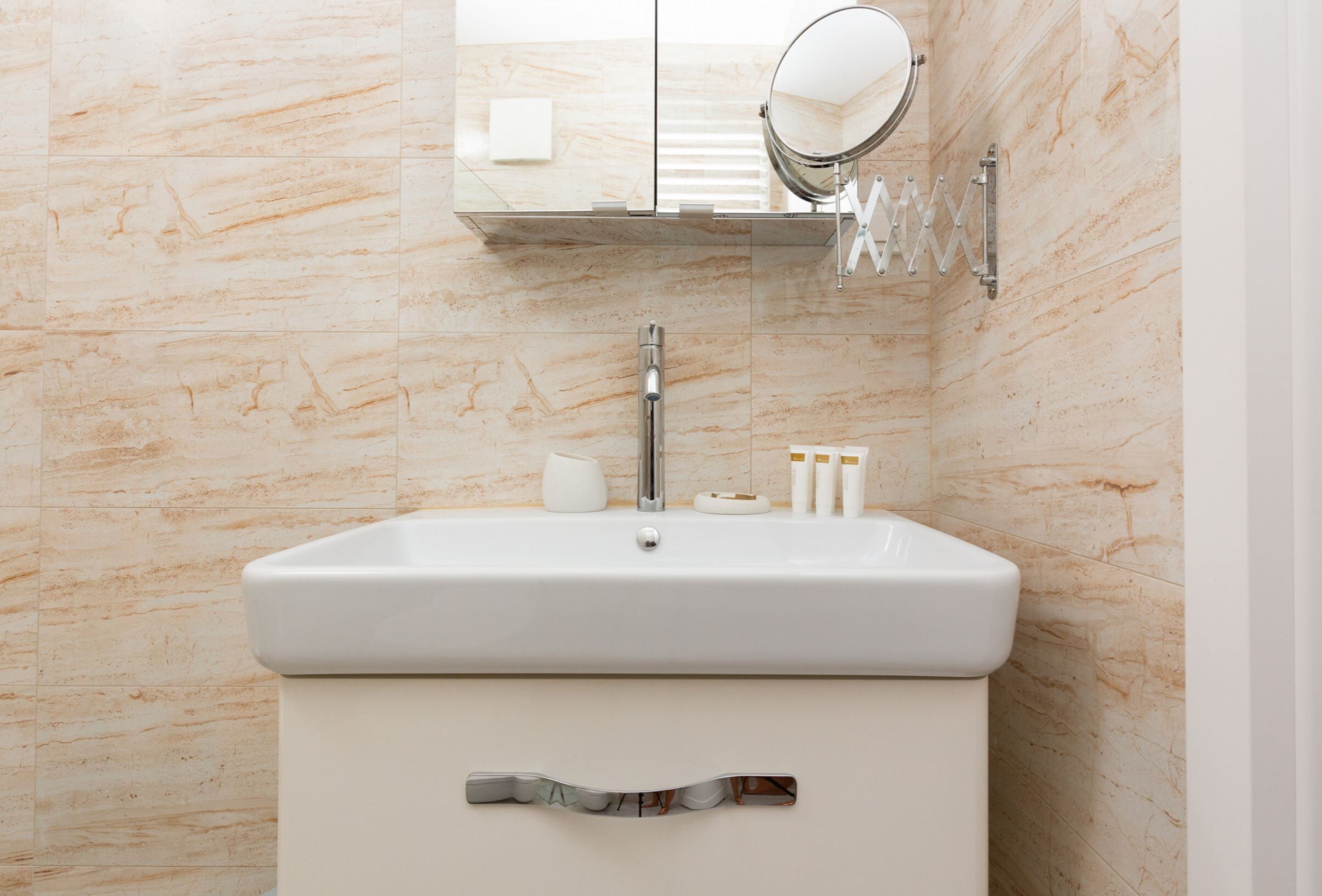Une salle de bain avec un lavabo blanc, un miroir et des toilettes.