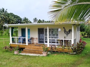A small house with a porch, a rooster decoration, and a garden. - "Jolly Rooster" Farm Cottage near famous Muri Beach  (Matavera)