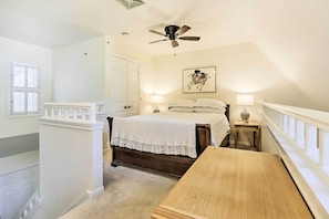 A bedroom with a bed, a ceiling fan, a nightstand, a lamp, and a window with blinds. - Lovely Norwich Villa, On Golf Course w/ Amenities! (Norwich)