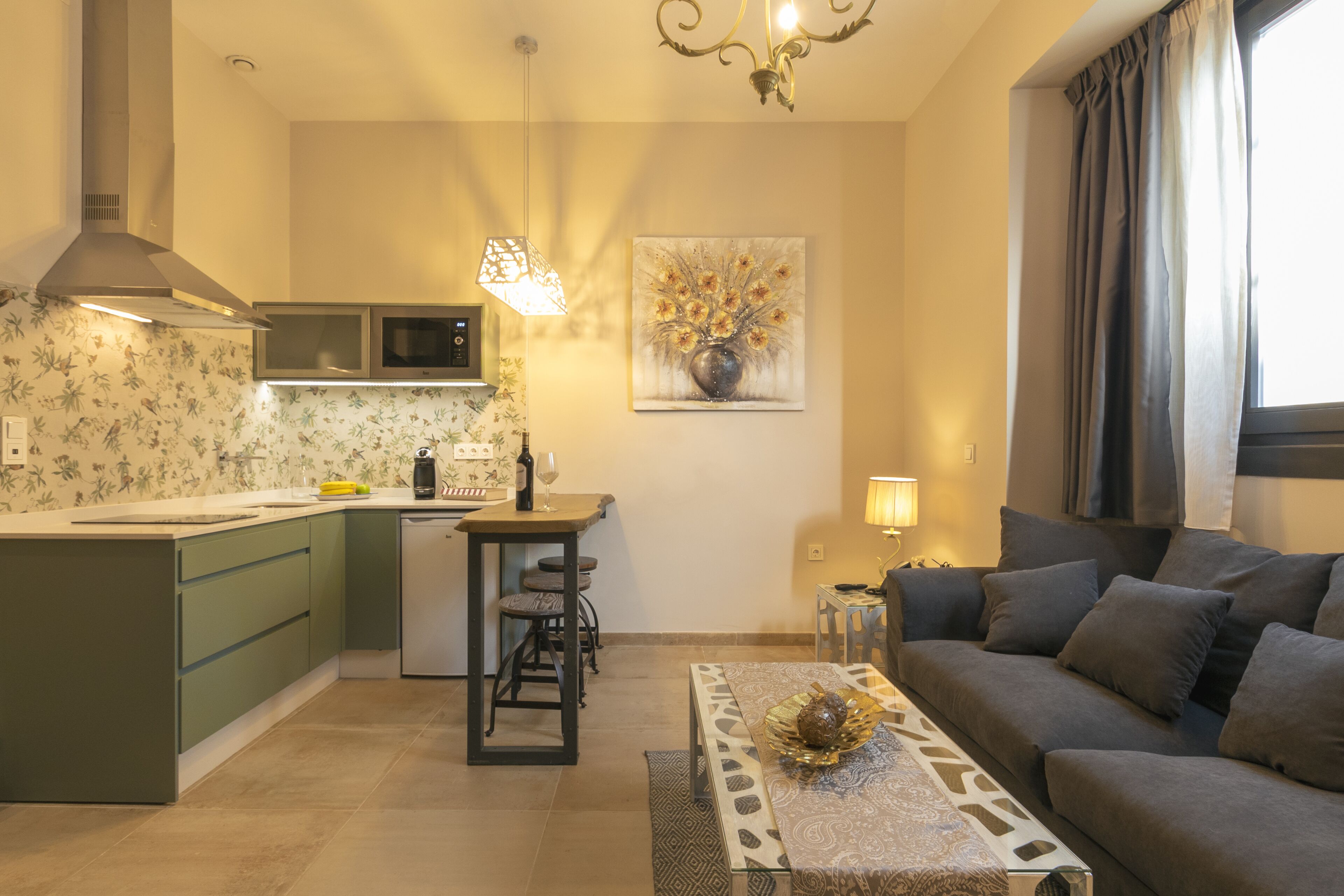 Een moderne keuken met een centraal eiland, een eetgedeelte met een tafel en stoelen, en een zithoek met een bank en een decoratietafel.