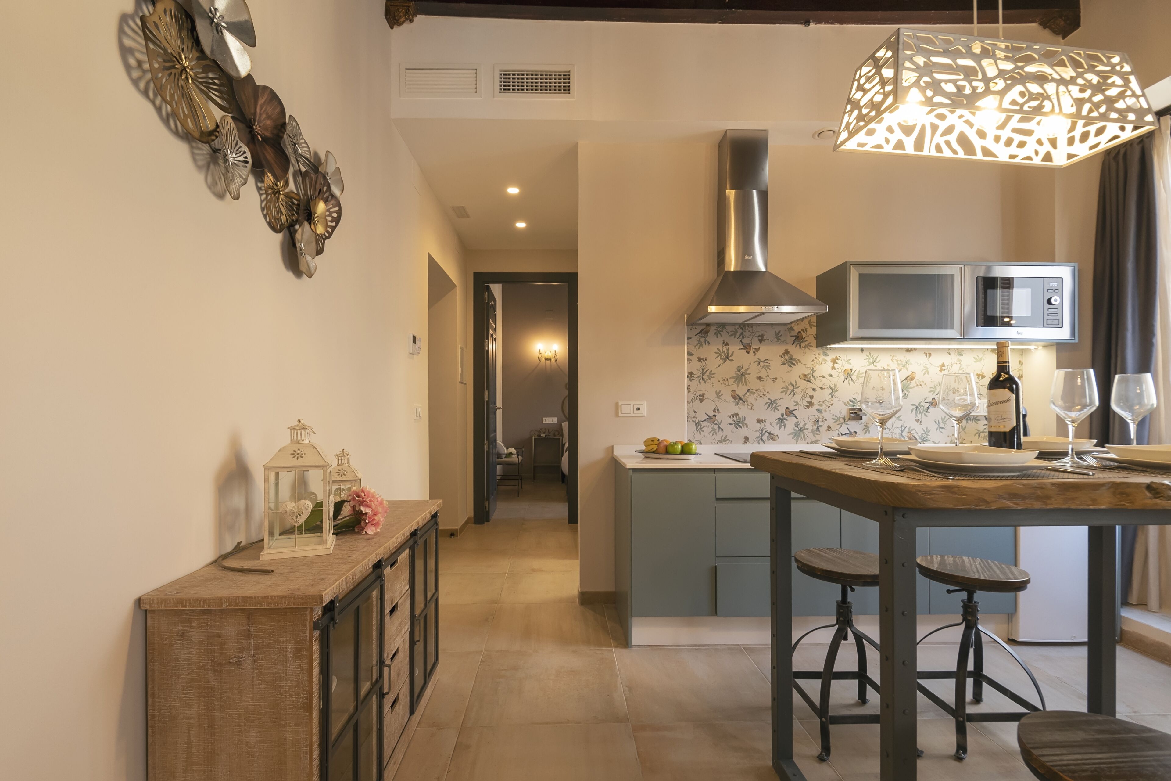 A modern kitchen with a central island, a microwave, and a hanging light fixture.
