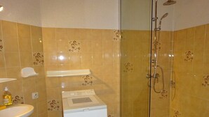A bathroom with a shower, a sink, and a washing machine. - Semi-detached duplex house of 50m² for 5 people (BISCARROSSE)