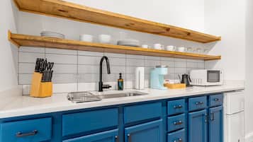 Een koelkast, kookgerei, borden en bestek