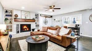 Una sala de estar moderna con chimenea, sofá de cuero y una mesa de centro.