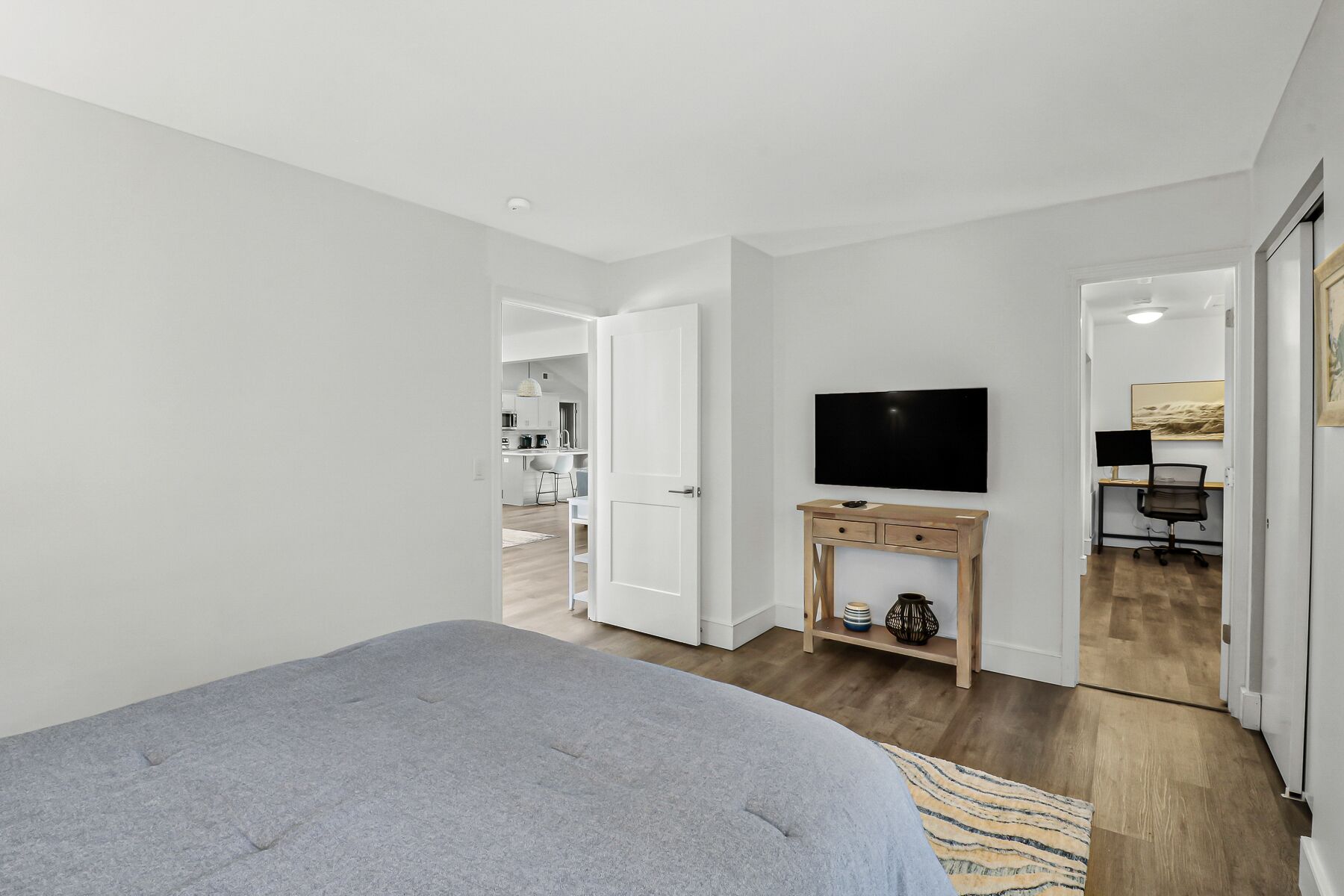 Une chambre moderne avec un grand lit, une télévision et un bureau équipé d’un ordinateur.