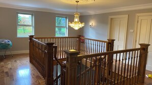 A spacious room with a wooden staircase, large windows, and a chandelier. - Beautiful 5 bedroom home in Mid Ulster- Magherafelt  (County Derry)