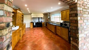 A spacious kitchen with a brick archway, wooden cabinets, and a tiled floor. - Beautiful 5 bedroom home in Mid Ulster- Magherafelt  (County Derry)