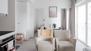 A modern living room with a sofa, a TV, and a dining area with a table and chairs. - Hiisi Homes Turku Elin Sagerin kuja (Turku)