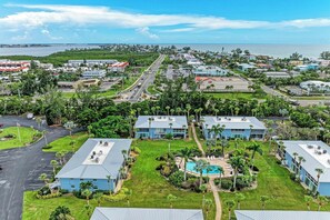 Zona residencial com casas, uma estrada e um corpo d'água ao longe.