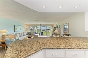 A spacious living area with a large granite countertop, a sofa set, and a view of the outdoors.