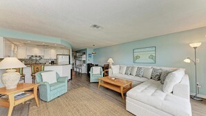 Ein modernes Wohnzimmer mit einer Couch, einem Couchtisch und einem Essbereich mit Stühlen.