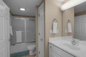 Un baño con ducha, inodoro y lavamanos.