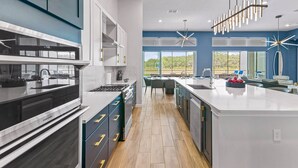 A modern kitchen with a central island, built-in appliances, and a view of the outdoors.