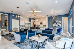 Relax in a stylish living space with a central seating area, kitchen, and dining area.