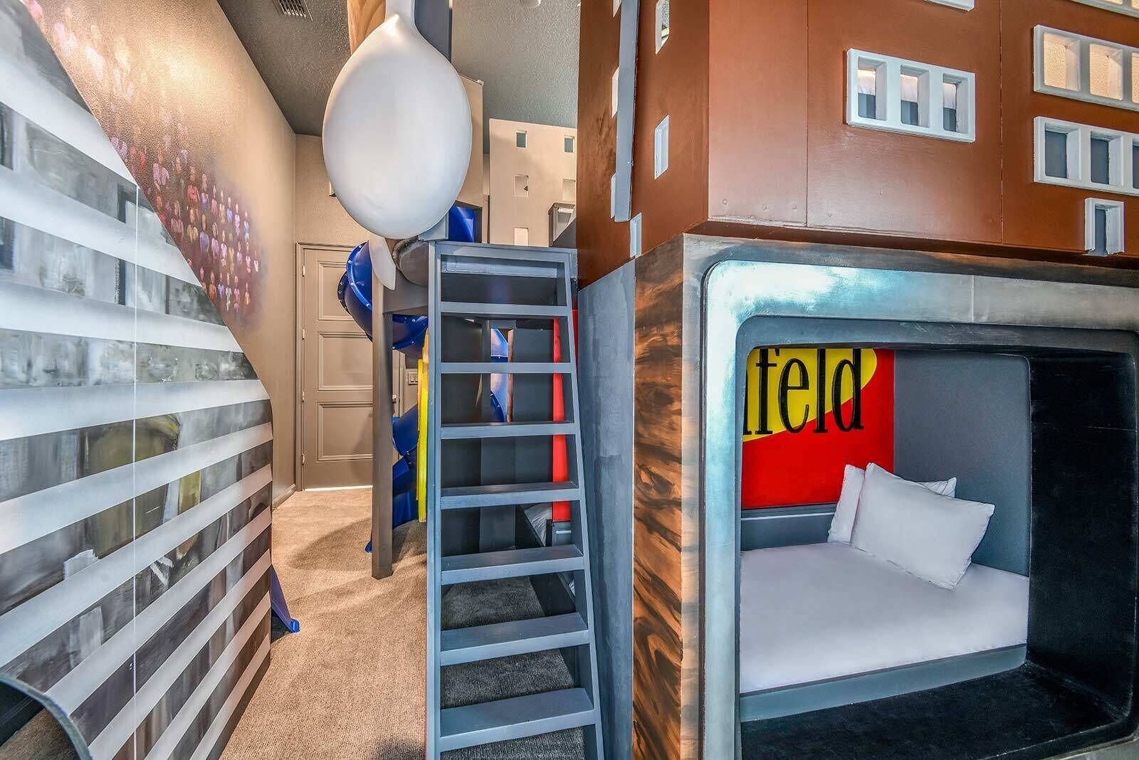 A room with a bunk bed, a ladder, and a wall with a colorful mural.