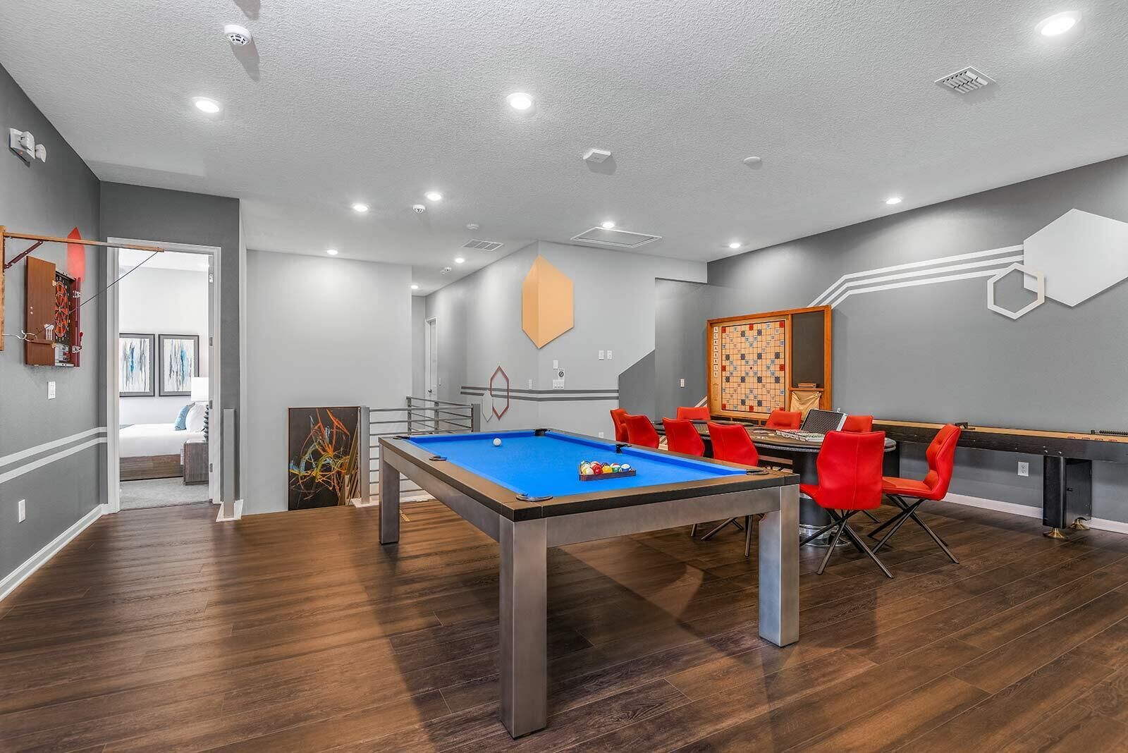 Une salle de loisirs moderne équipée d’une table de billard, de chaises rouges et d’un jeu d’échecs.
