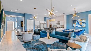 Un salon moderne avec un canapé bleu, une table basse et un coin repas comprenant une table et des chaises.