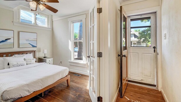 Une chambre à coucher avec un lit, un ventilateur de plafond et une fenêtre.