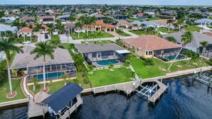 Zona residencial con casas, piscina y muelle junto al agua.